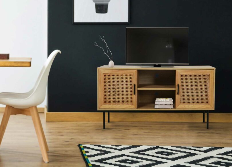 meuble pour la télé en bois avec pieds noir et rotin