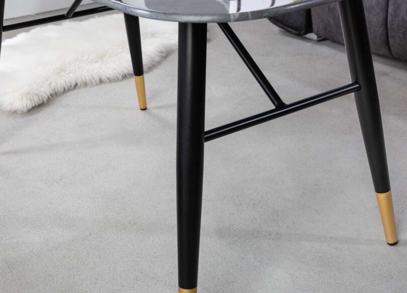 zoom sur les pieds en metal noir et pointes dorees