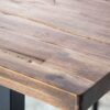 zoom sur le plateau en bois fonce avec planches irregulieres et effet latte