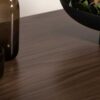 Zoom sur le bois aspect noyer de la table haute de bar