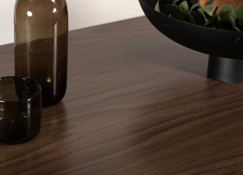 Zoom sur le bois aspect noyer de la table haute de bar