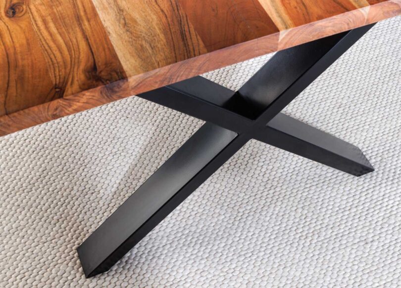 Zoom sur le bois d'acacia et le piétement en métal noir de la table à manger