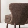 fauteuil de détente avec un repose-pieds en tissu bouclé blanc et pieds en métal noir