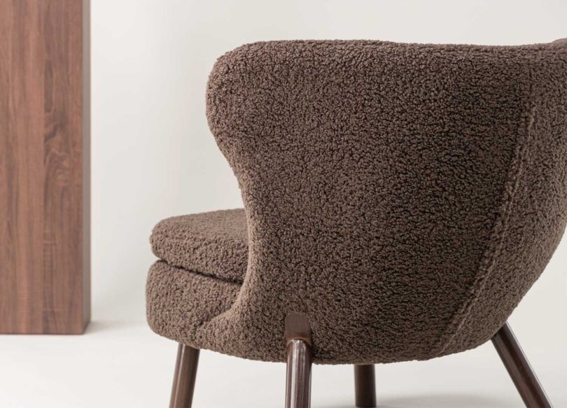 fauteuil de détente avec un repose-pieds en tissu bouclé blanc et pieds en métal noir