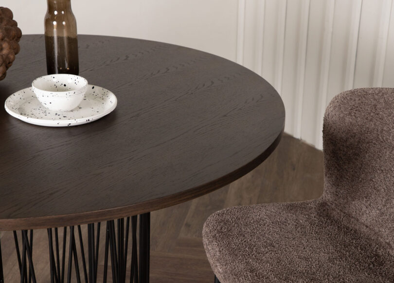 table de salle à manger moderne ronde en mdf aspect bois foncé et pieds design original en métal noir