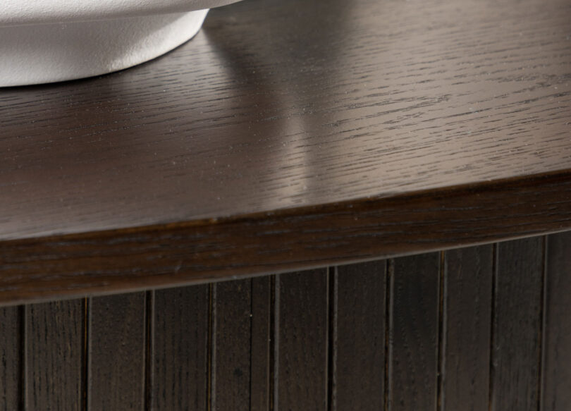 Zoom sur le plateau ovale de la table basse foncé