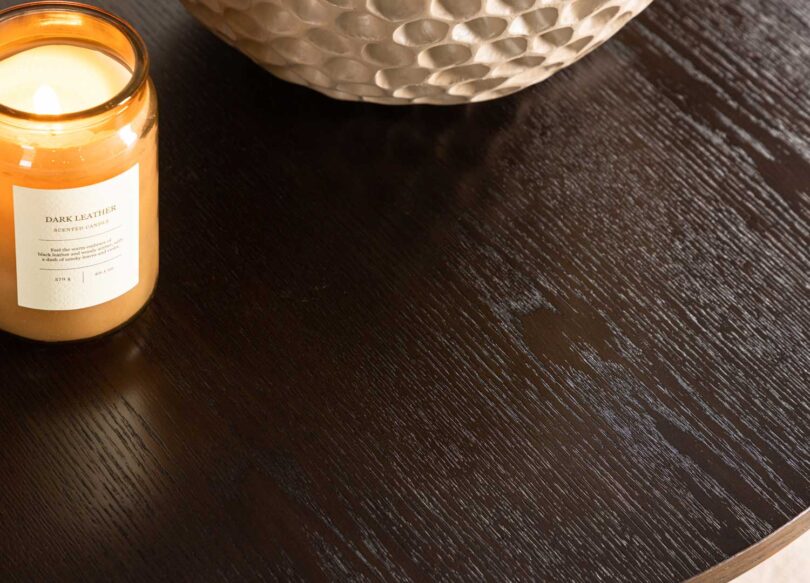 Zoom sur le plateau de la table basse ronde aspect bois de noyer foncé