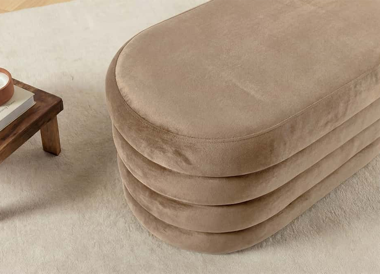 Gros plan sur le velours taupe champagne du banc coffre ELYA et ses reflets lumineux