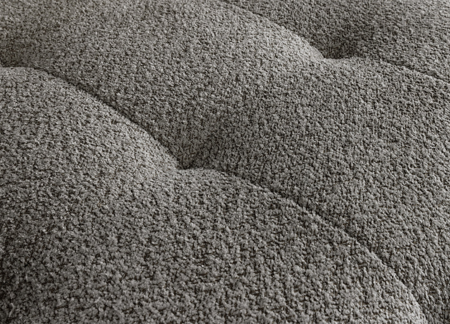 Détail de l’assise capitonnée du canapé ASTORIA en tissu bouclé gris