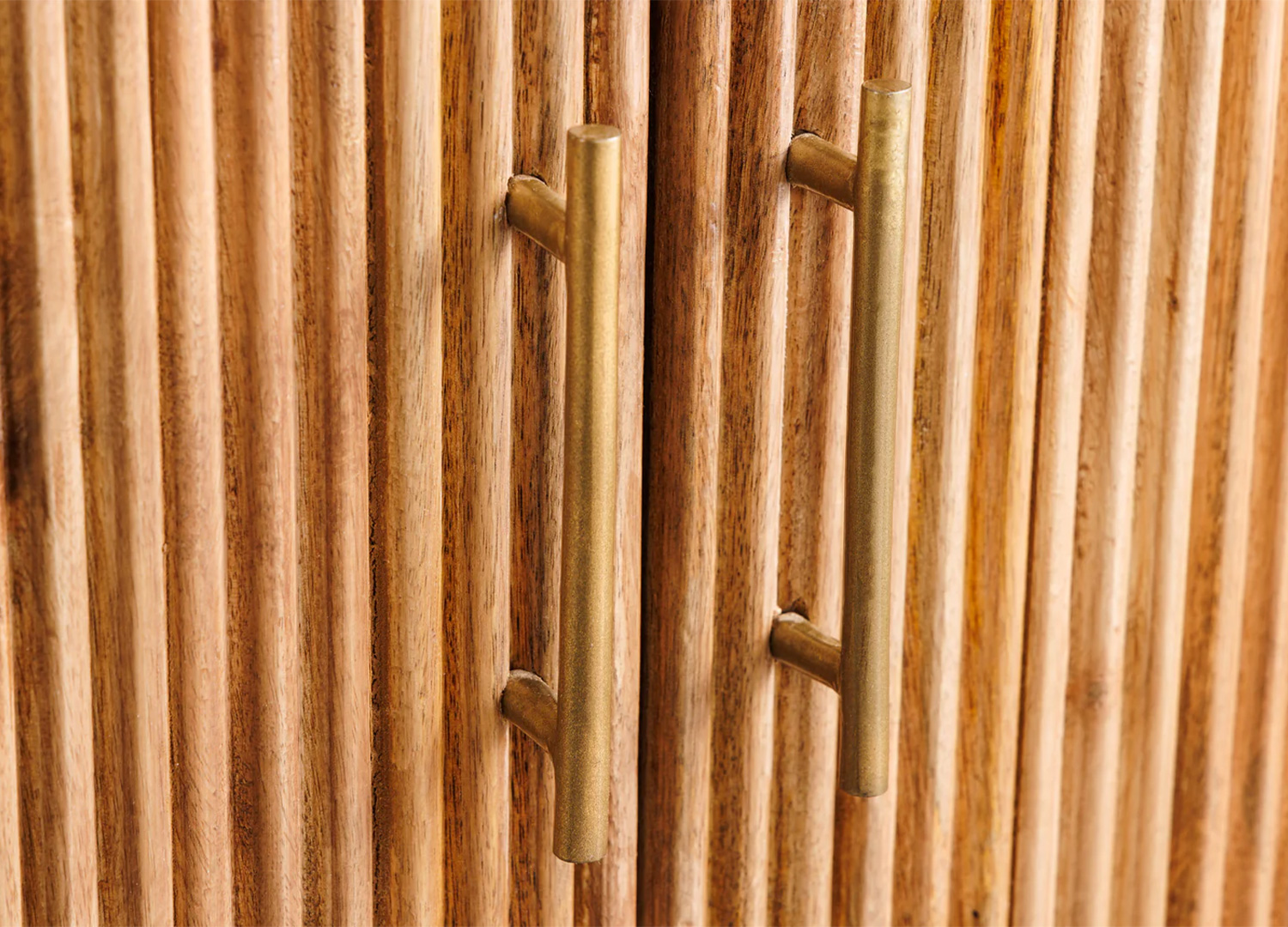 Détail des poignées dorées de la commode MARELLO sur façade striée en bois de manguier