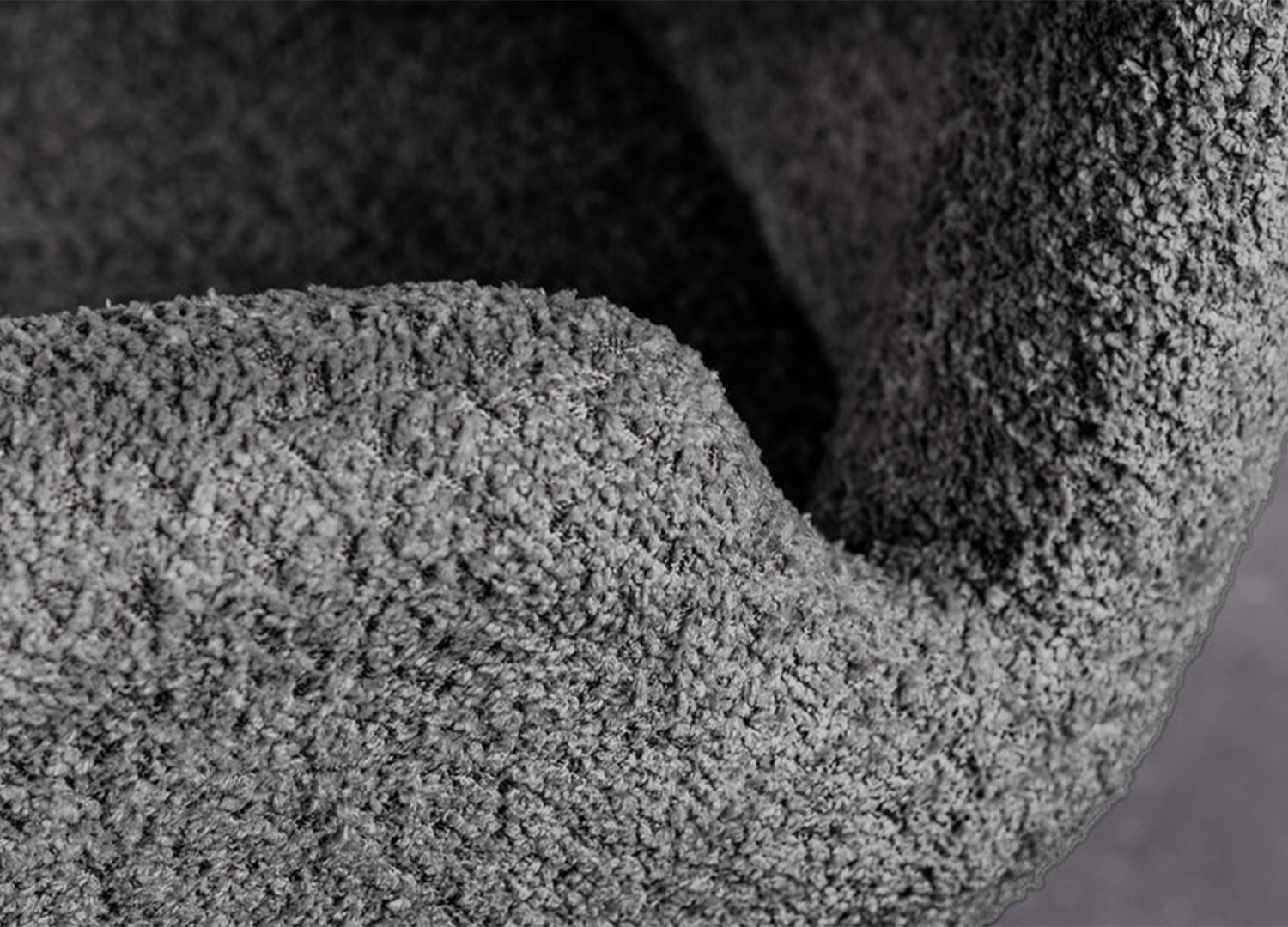 Détail de l’assise rembourrée et du tissu bouclé d’une chaise LIORA gris anthracite