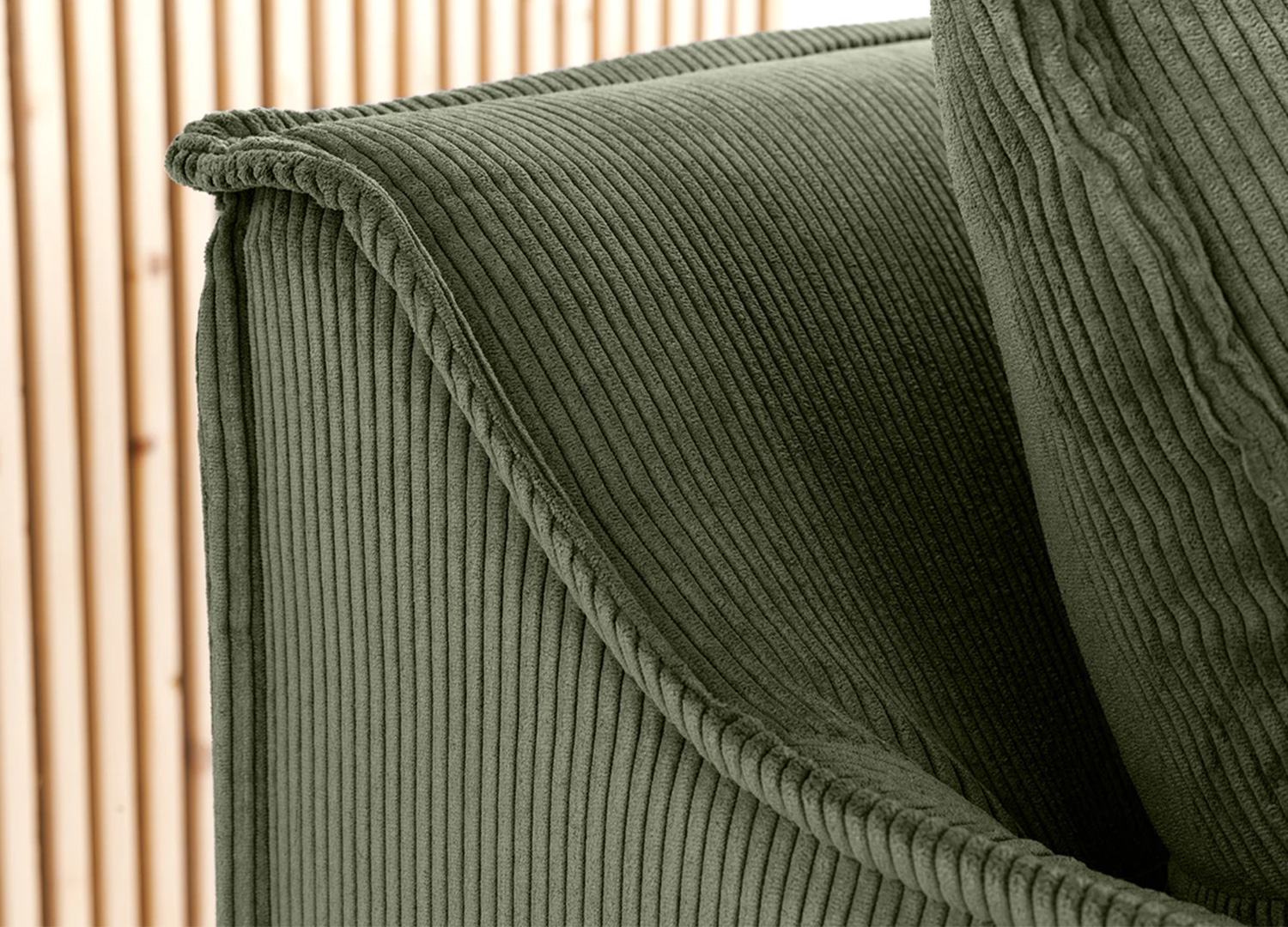 Détail de l’accoudoir du canapé MILO en velours côtelé vert