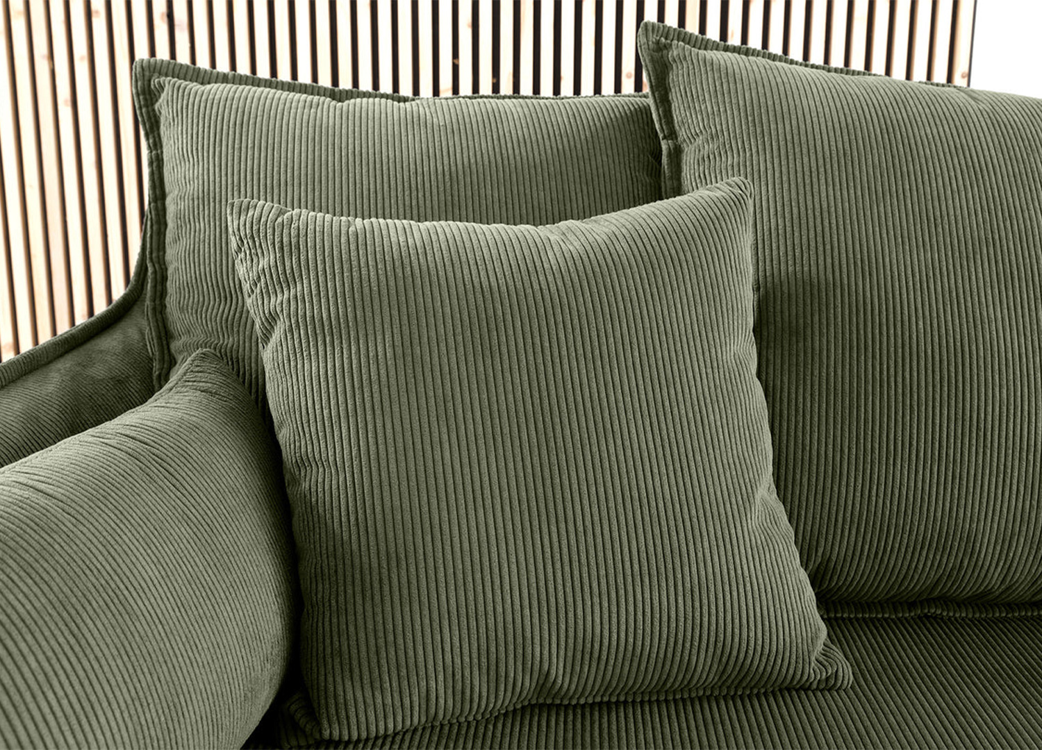 Détail d’un coussin du canapé MILO en velours côtelé vert