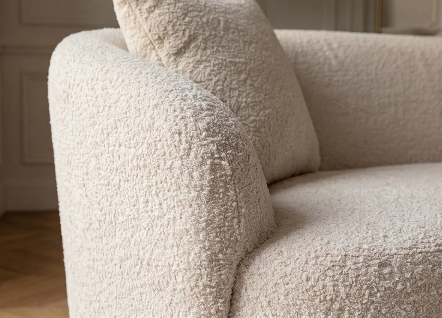 Détail du tissu bouclé beige et de l’assise confortable du canapé SOLANE