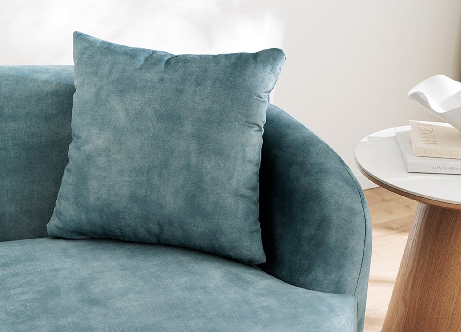 Zoom sur l’assise et le coussin du canapé SOLANE en velours bleu pétrole