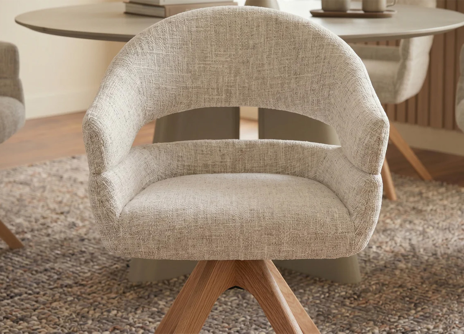 Vue rapprochée de la chaise pivotante NÉLIA en chenille beige avec accoudoirs enveloppants