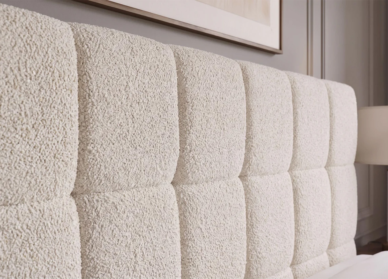 Vue de profil de la tête de lit rembourrée MÉRÉA en tissu bouclé crème