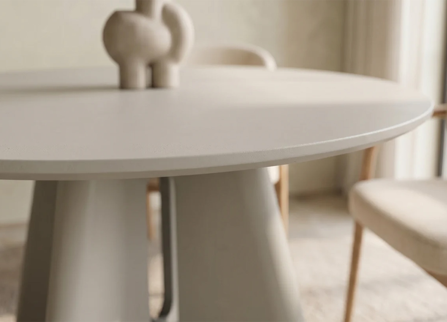 Gros plan sur le chant fin et la finition vernie du plateau rond de la table ÉLORIA