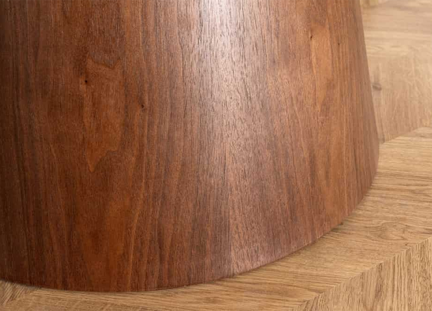 Détail du veinage du placage noyer sur le pied conique de la table ronde ÉLIORA