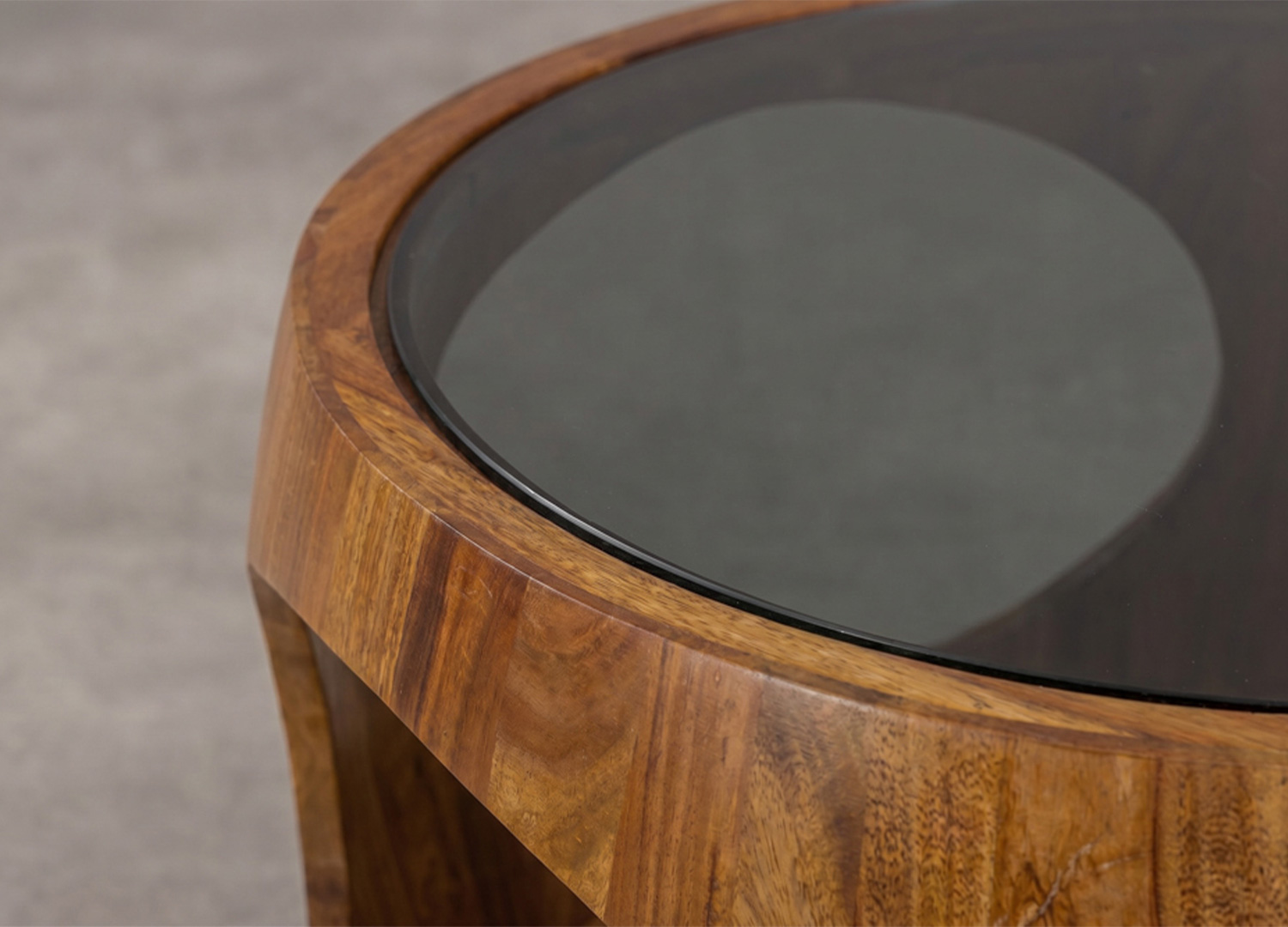 Gros plan sur le plateau en verre noir et la finition du bois de sheesham de la table basse KARSA