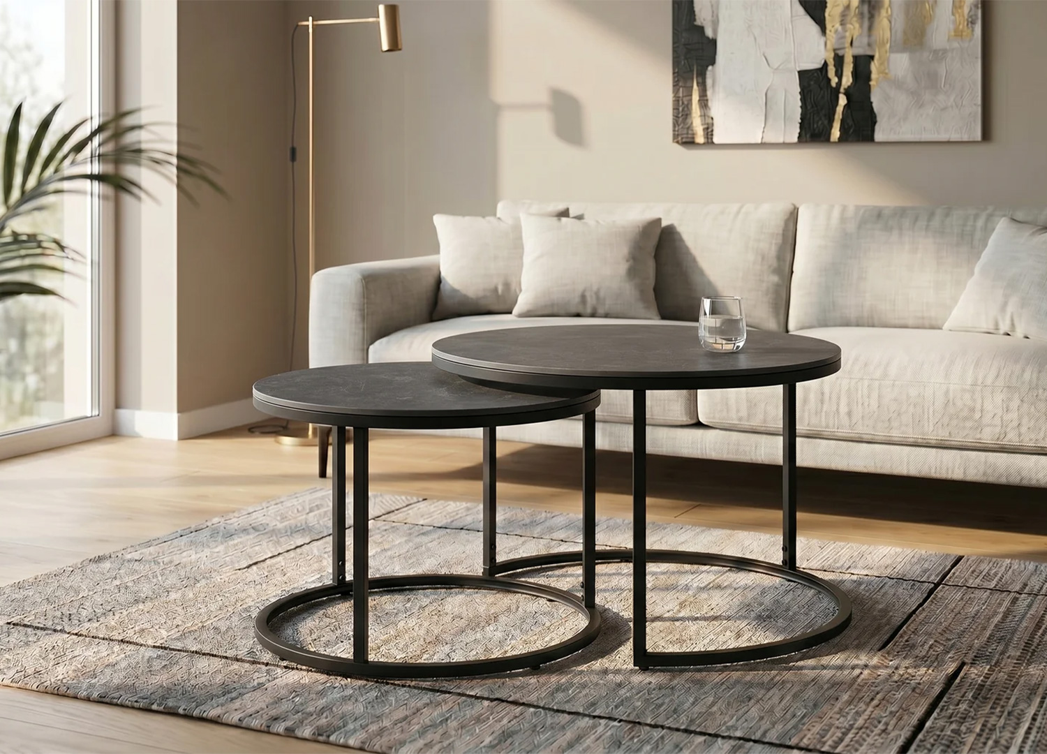 Ensemble de tables basses gigognes KAVEN en céramique anthracite devant un canapé en tissu beige