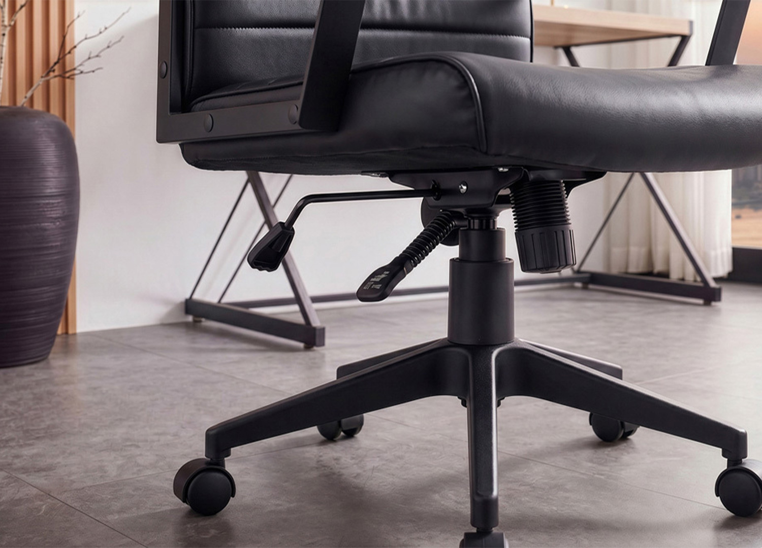 Détail du mécanisme de réglage en hauteur et de la fonction bascule sous l’assise du fauteuil SÉVAN