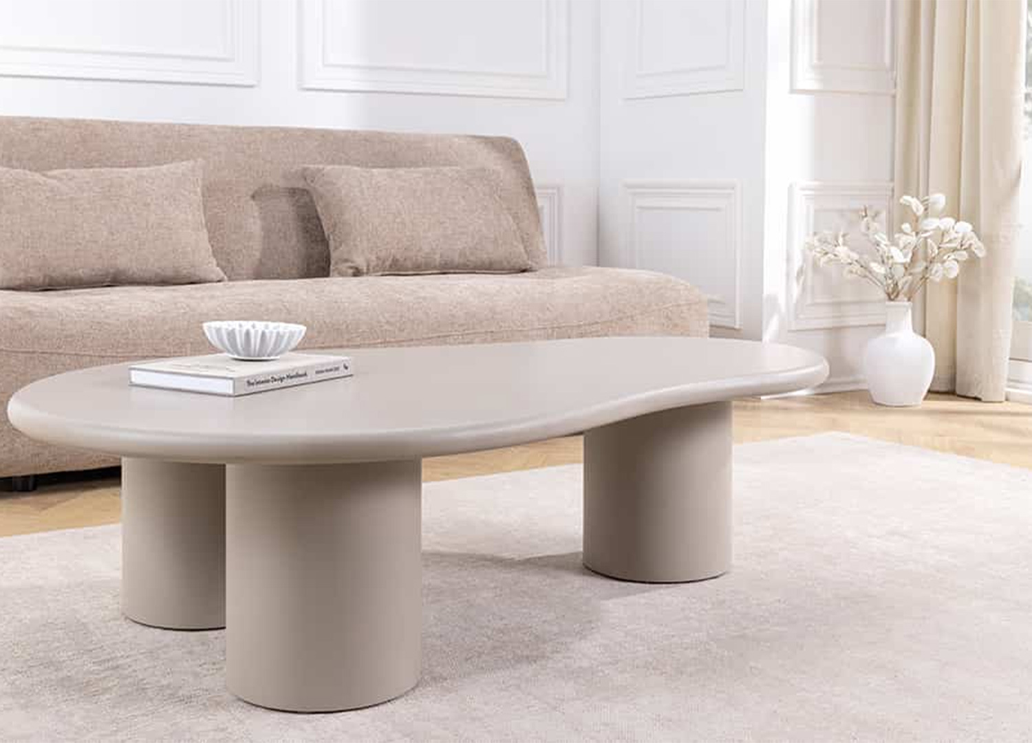 Table basse organique NÉRAYA 130 cm greige beige dans un salon beige et lumineux