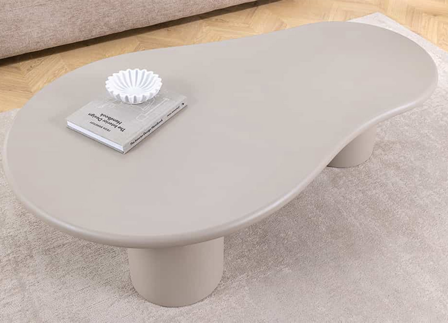 Plateau organique de la table basse NÉRAYA 130 cm greige beige vu de dessus avec livre