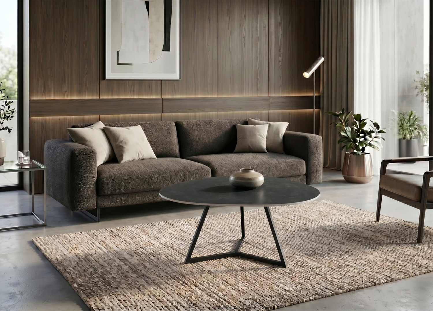 Table basse ORBIS 90 cm en céramique anthracite placée devant un grand canapé gris