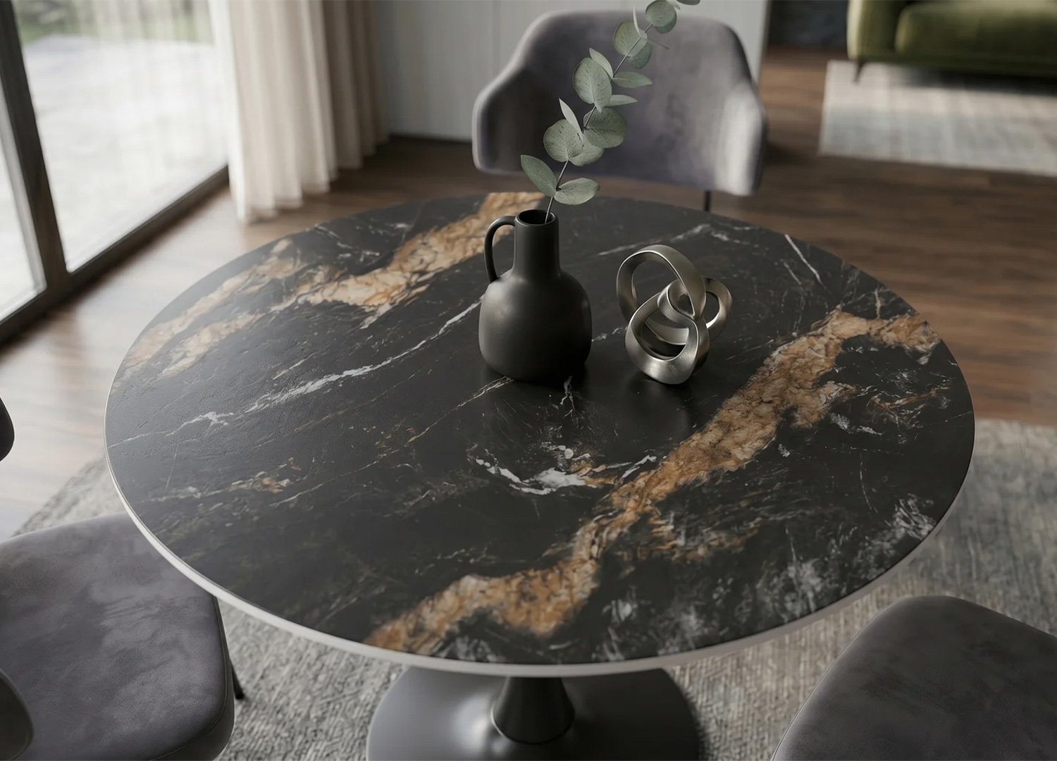 Gros plan sur le plateau en céramique noir doré et sable de la table ORBIS