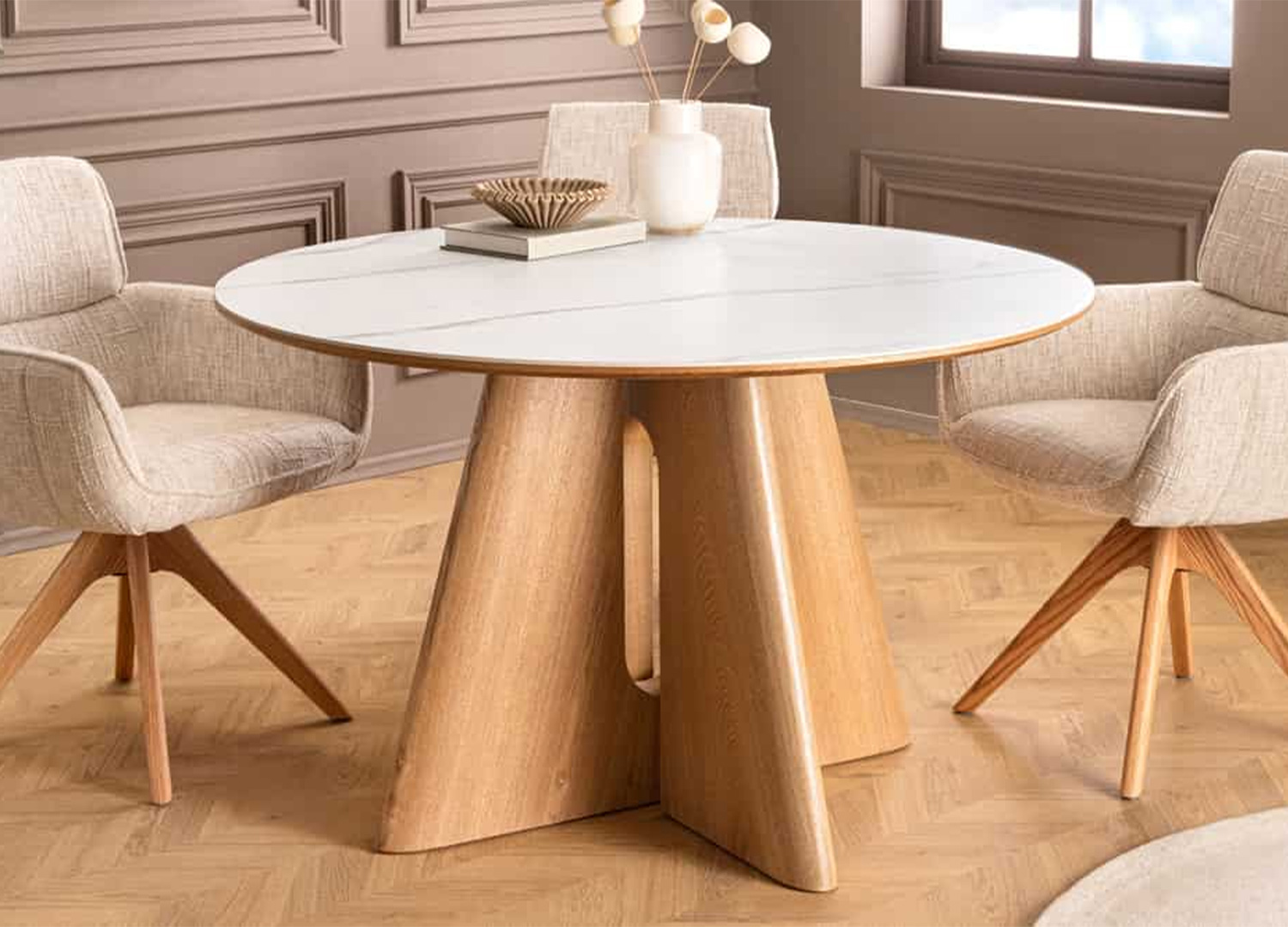 Table ronde ÉLIORA 120 cm effet marbre blanc installée avec quatre chaises en tissu beige