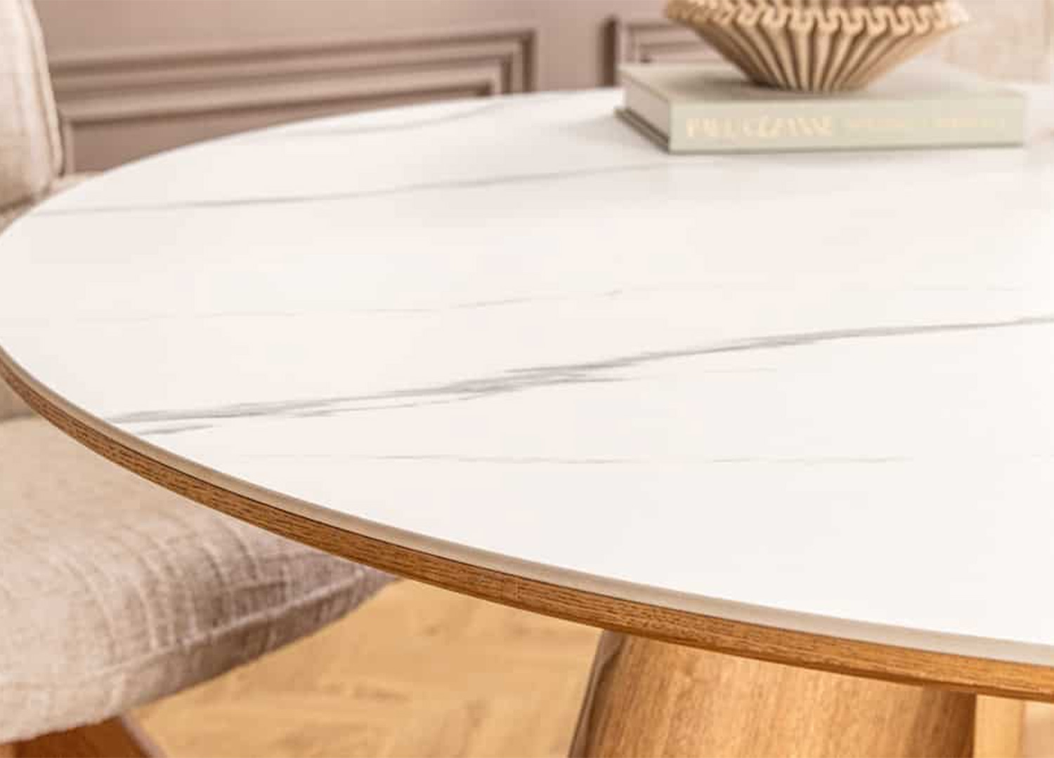 Gros plan sur le plateau en céramique effet marbre blanc de la table ronde ÉLIORA