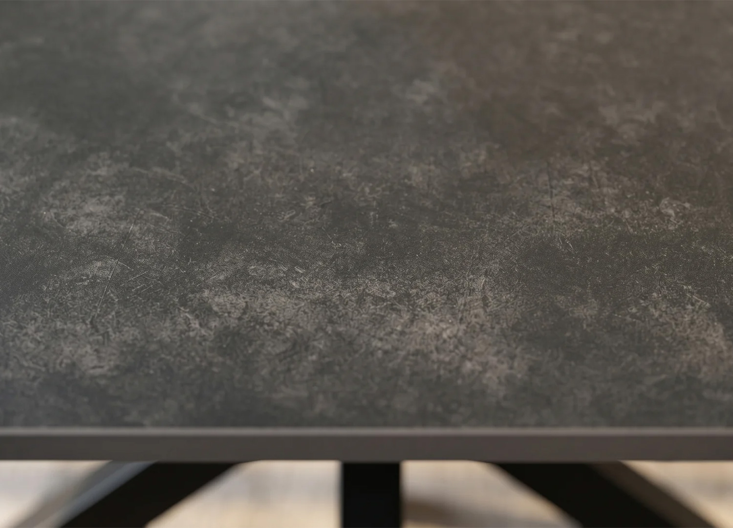 Gros plan sur le plateau effet pierre anthracite de la table KAVEN 180 cm