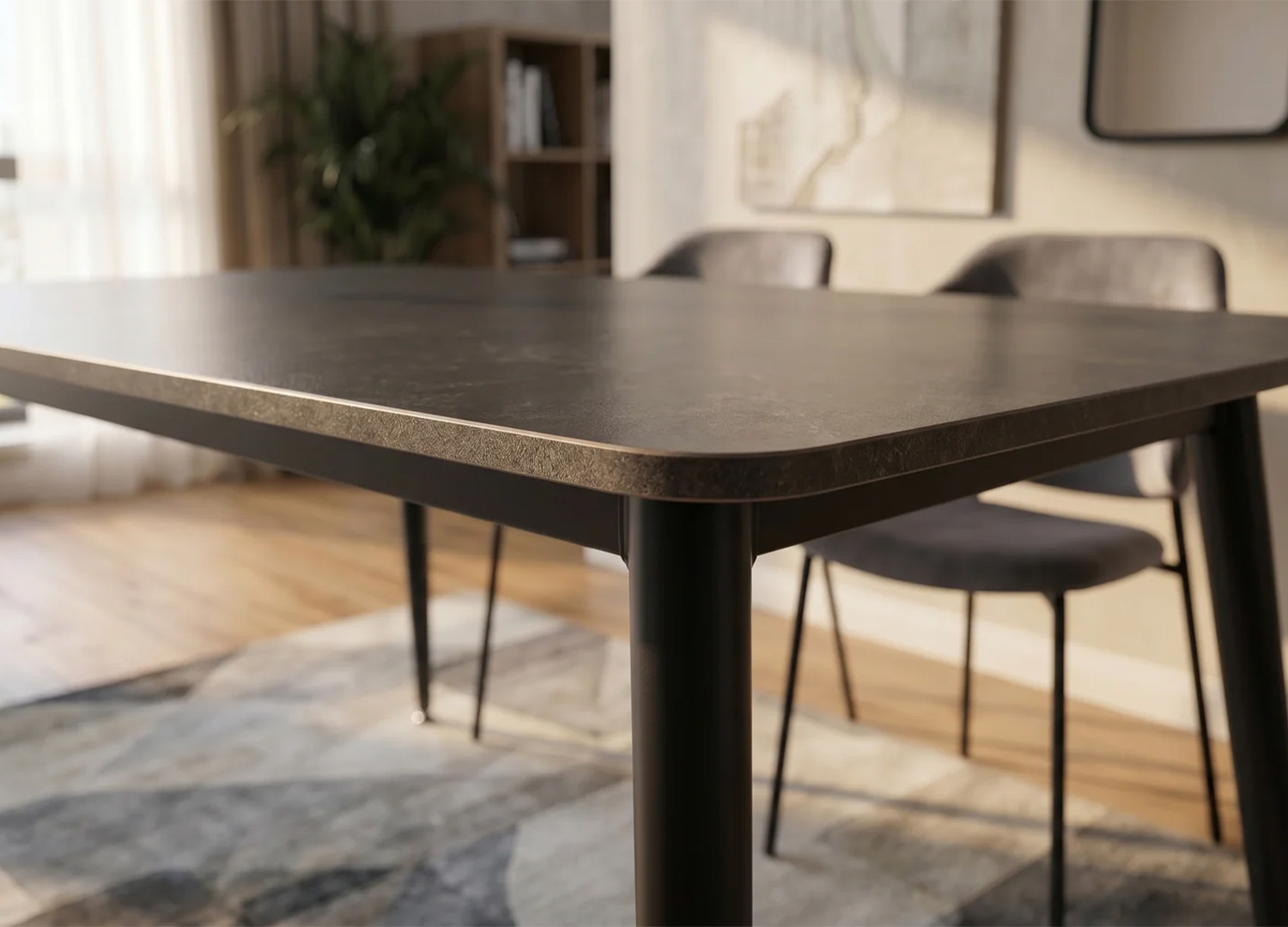 Détail des coins arrondis de la table KAVEN en céramique anthracite avec piètement métal noir