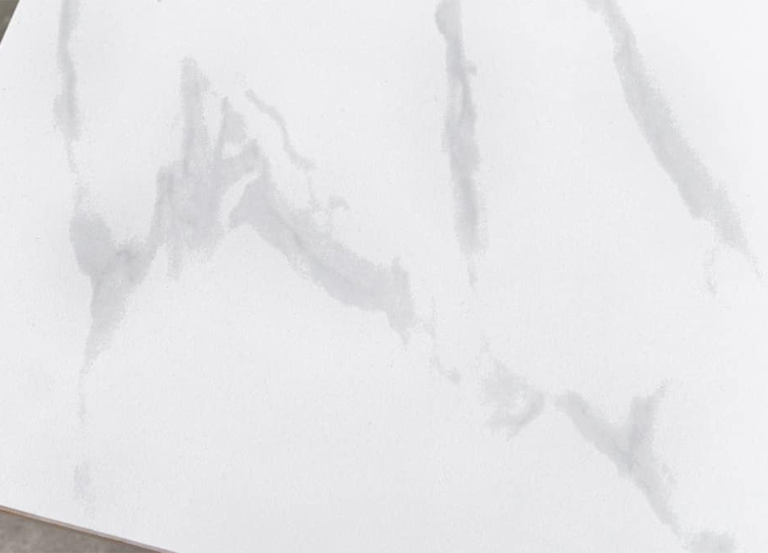 Détail du plateau en céramique blanche effet marbre de la table KAVEN 140 cm