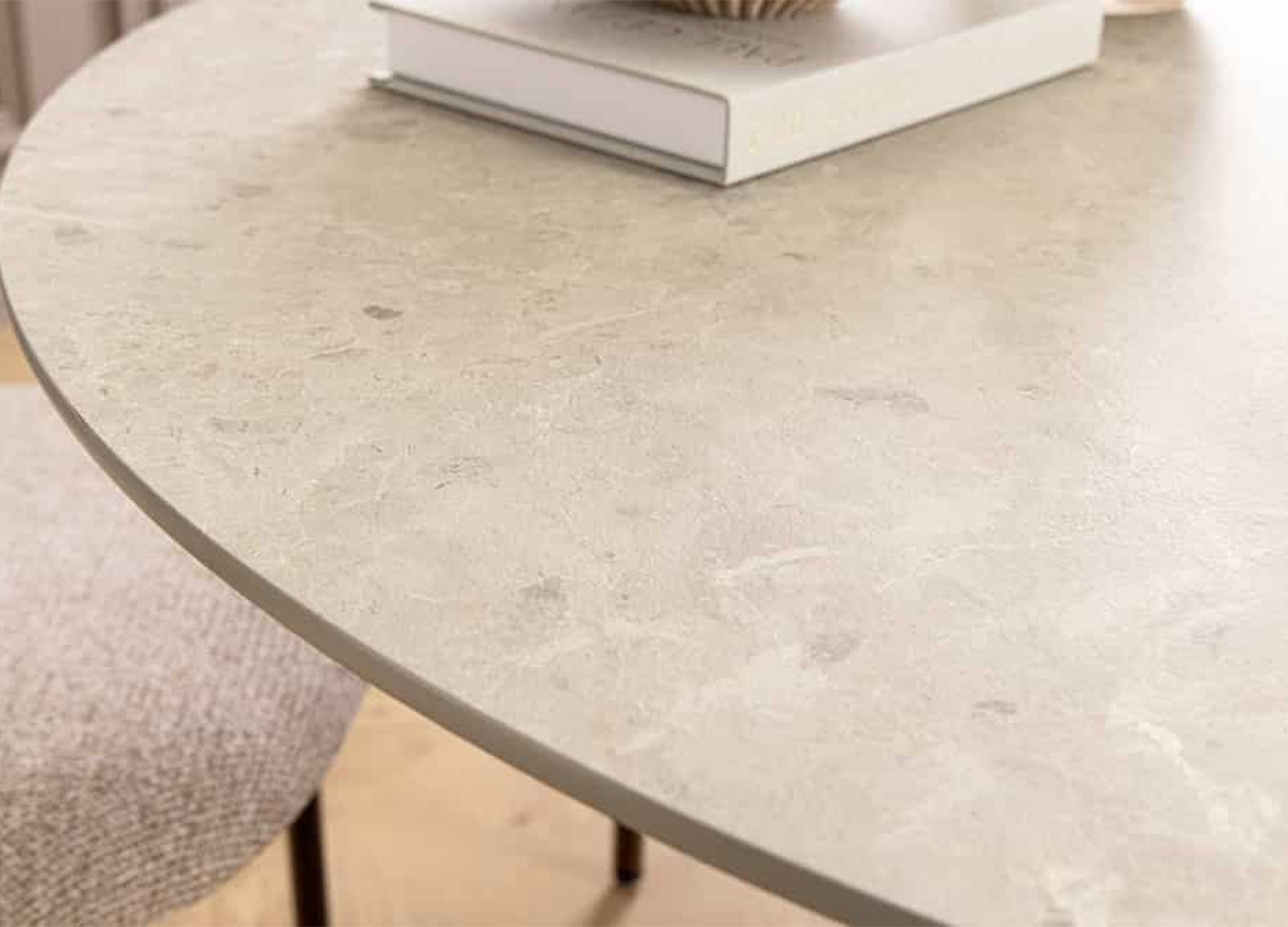 Zoom sur le chant arrondi du plateau effet béton gris de la table ronde ÉLORIA