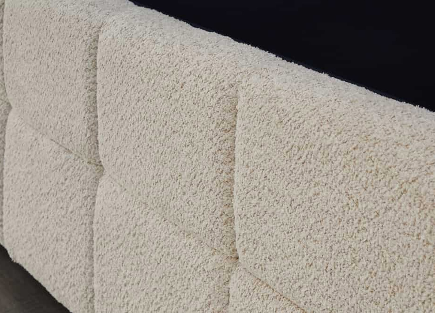Gros plan sur le revêtement en tissu bouclé crème du lit coffre MÉRÉA