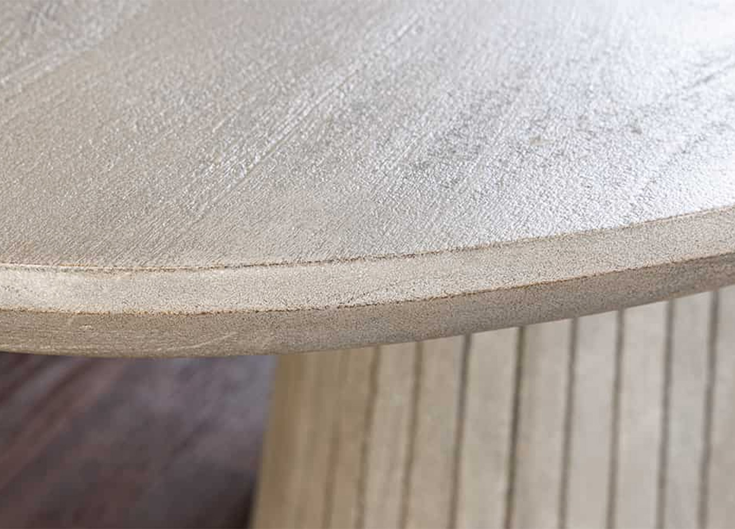 Détail du chant arrondi et de la finition gris fumé du plateau ovale de la table SÉVÉRIA