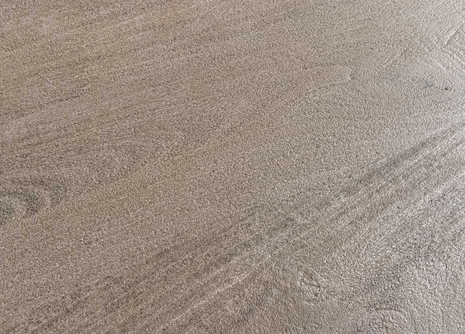 Gros plan sur la surface légèrement texturée du plateau en manguier massif gris fumé de la table SÉVÉRIA